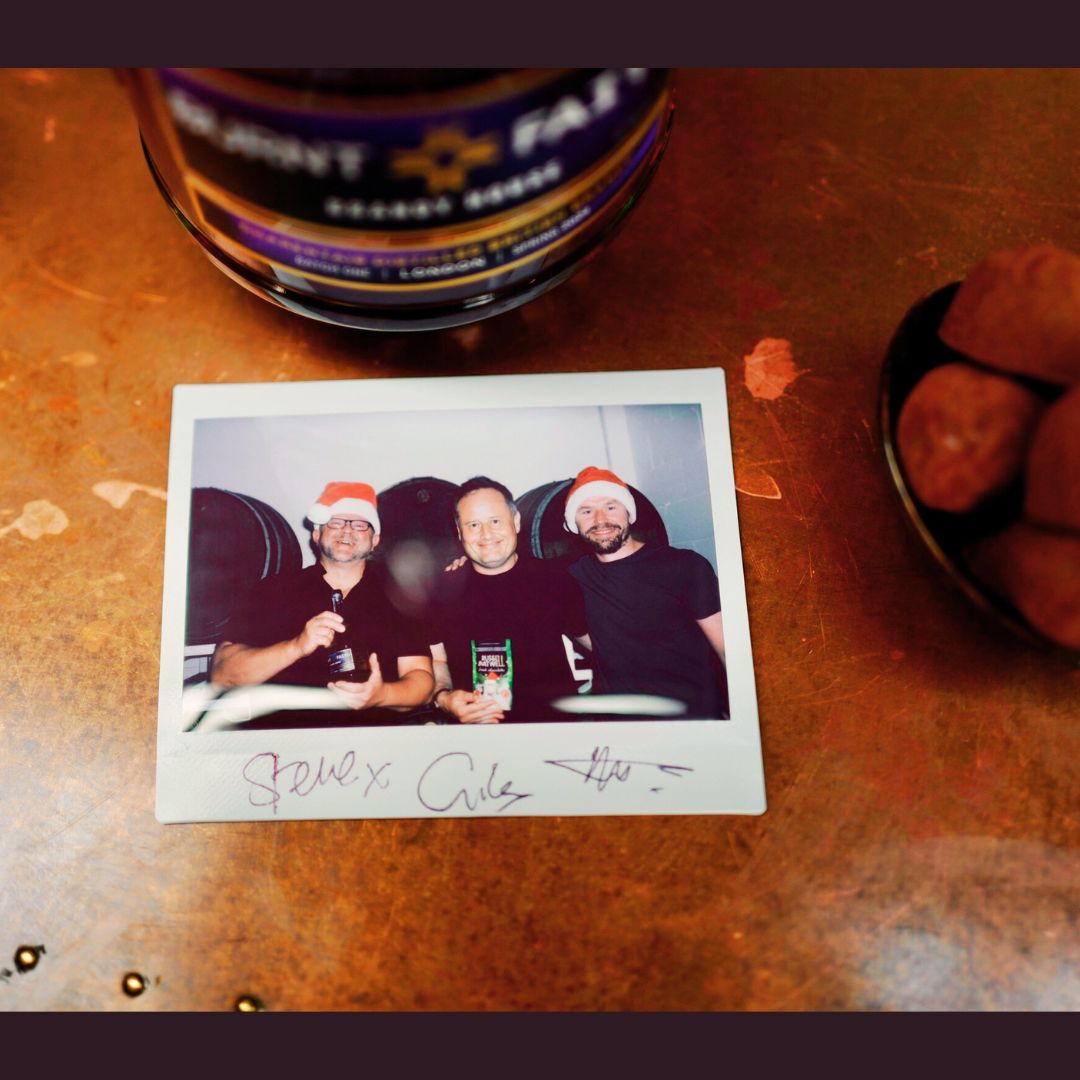 Polaroid photo of three people with a bottle and snacks on a table